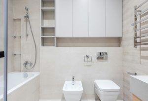 A clean and minimalistic bathroom featuring a bathtub, bidet, and modern fixtures.